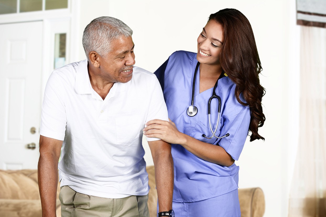 A home health professional offering support to an older man in his home